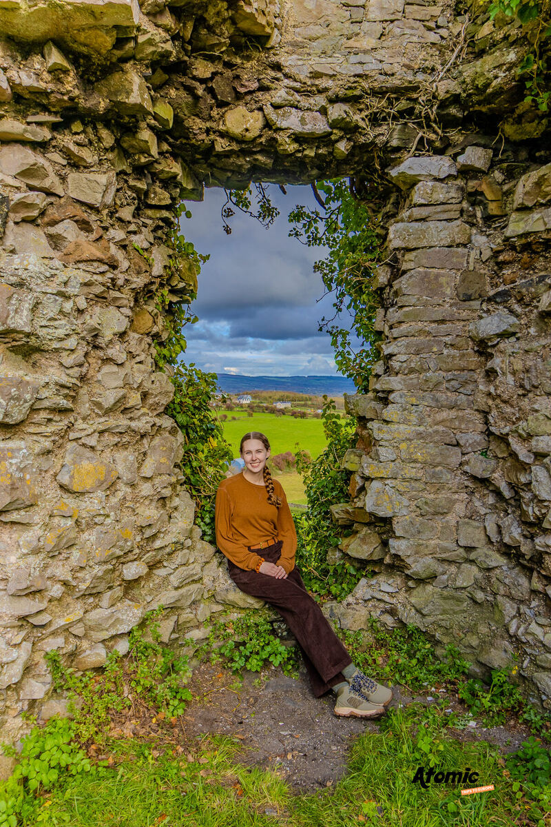 An Atomic Trips traveler in a stone castle window overlooking the Irish countryside